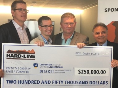 Un grand chèque de 250.000$ est affiché avec le logo de Hard-line