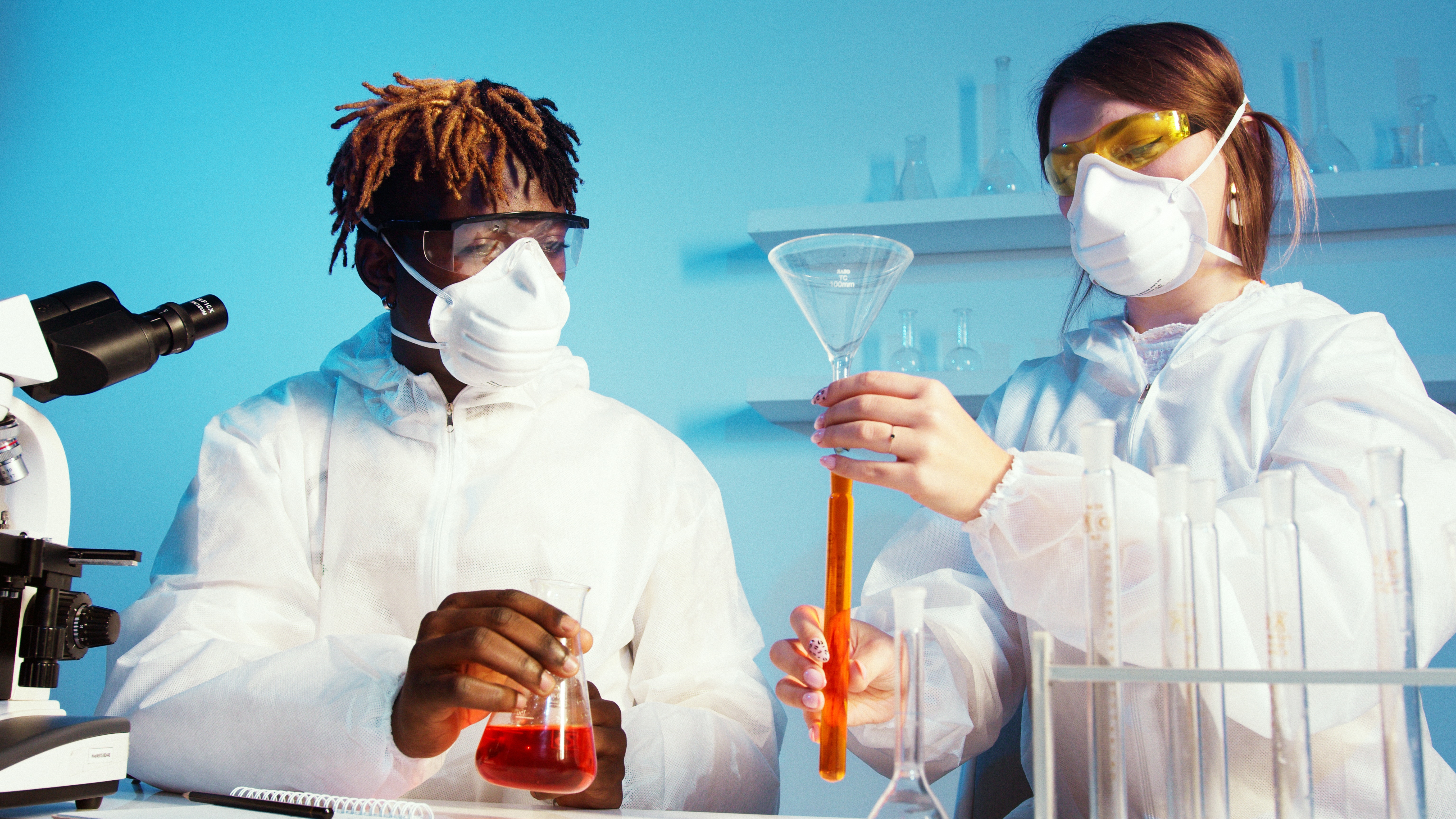 Deux élèves tiennent des tubes à essai contenant des substances différentes. 