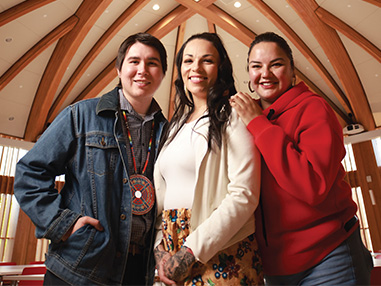 Trois membres de la communauté autochtone de la Laurentienne souriant à l'intérieur du centre autochtone de partage et d’apprentissage