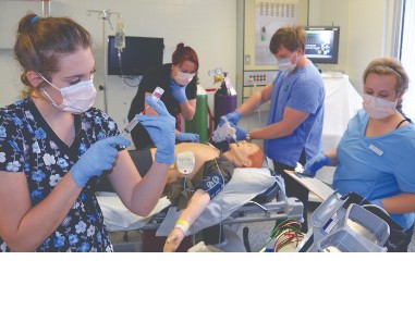 Les étudiants en soins infirmiers s'exercent sur un mannequin d'essai