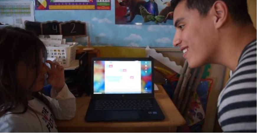 Un homme et un jeune enfant devant un ordinateur dans un cadre éducatif