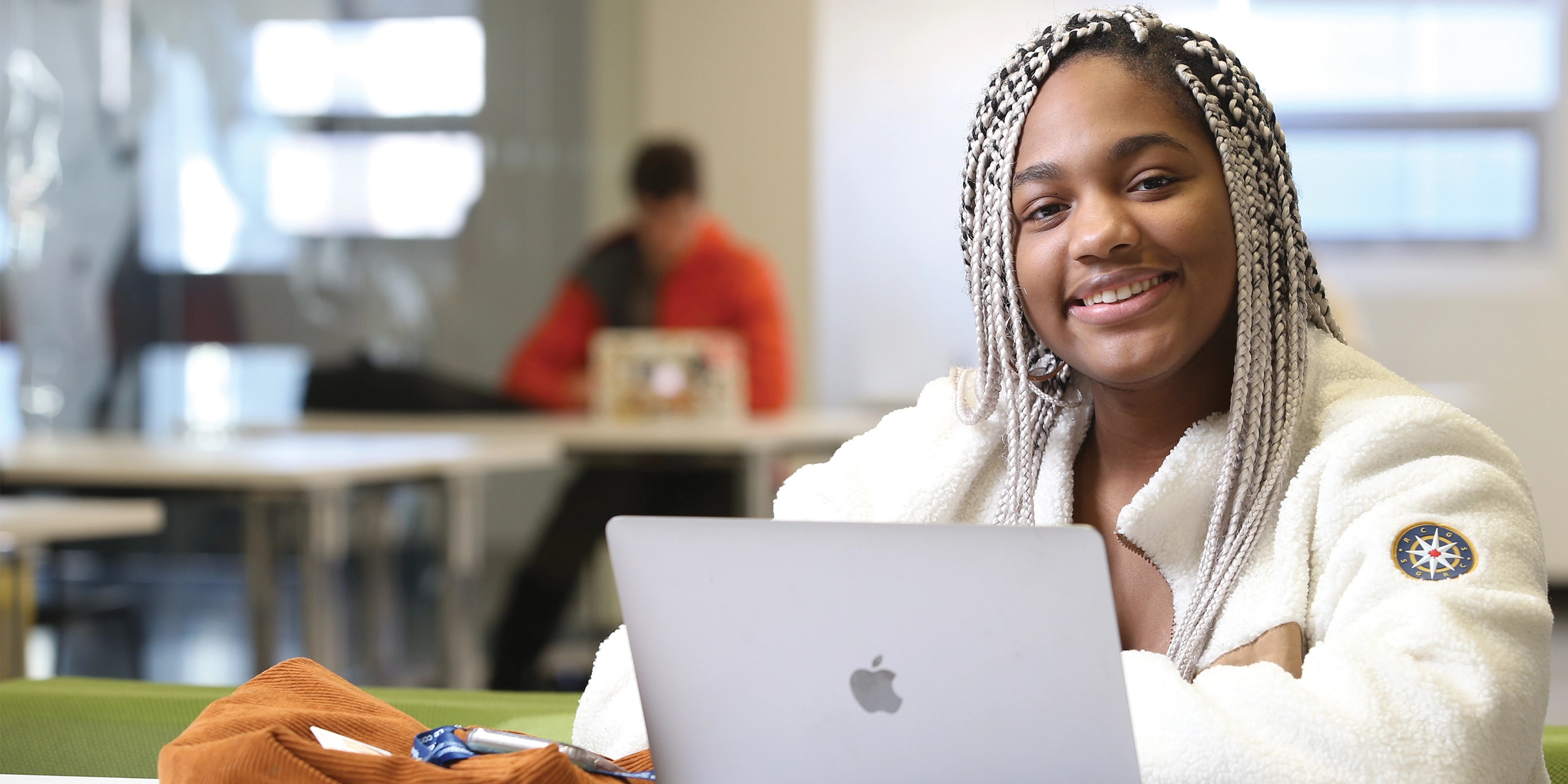 Une étudiante de l'Université Laurentienne assise avec son portable ouvert.