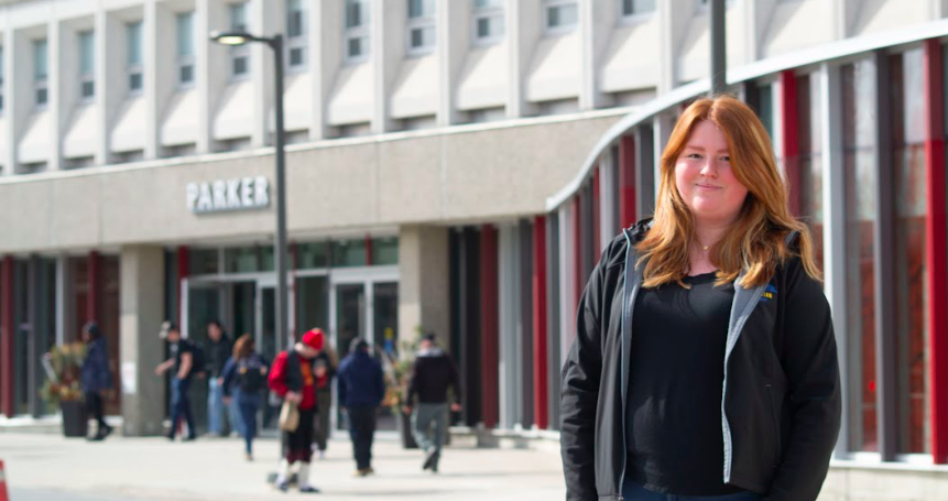 Future educator and Laurentian student, Emily Henry, standing in front of the Parker Building on campus.
