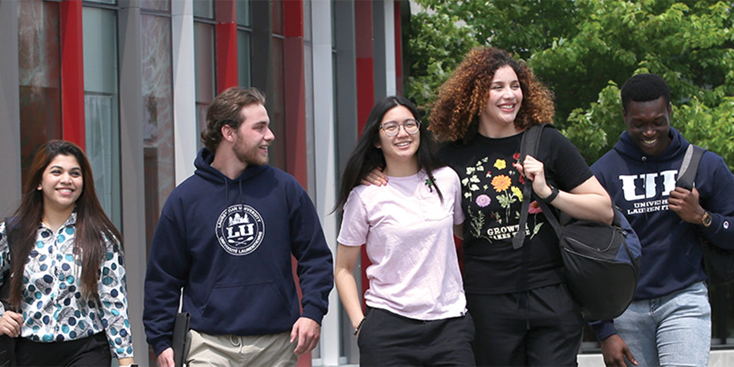 5 students walking outside of the student center