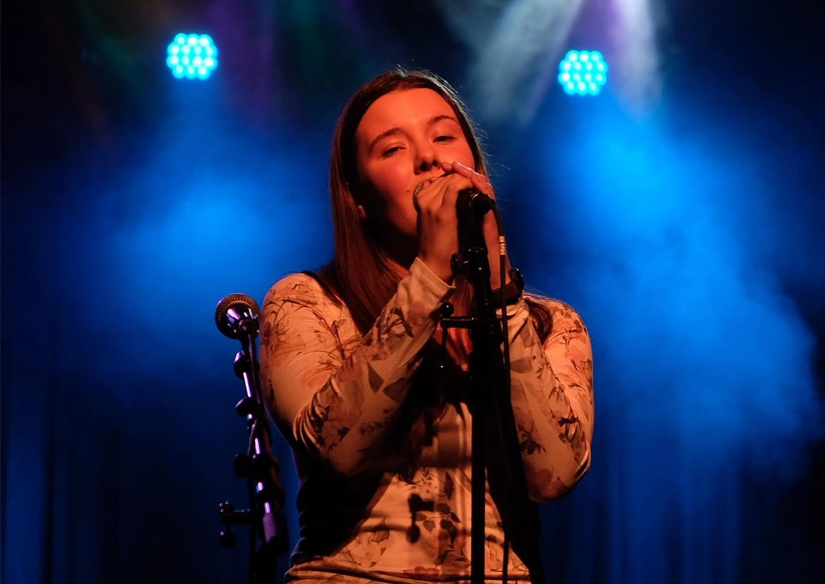 A Laurentian University student on stage singing for the Laurentian Talent Show.