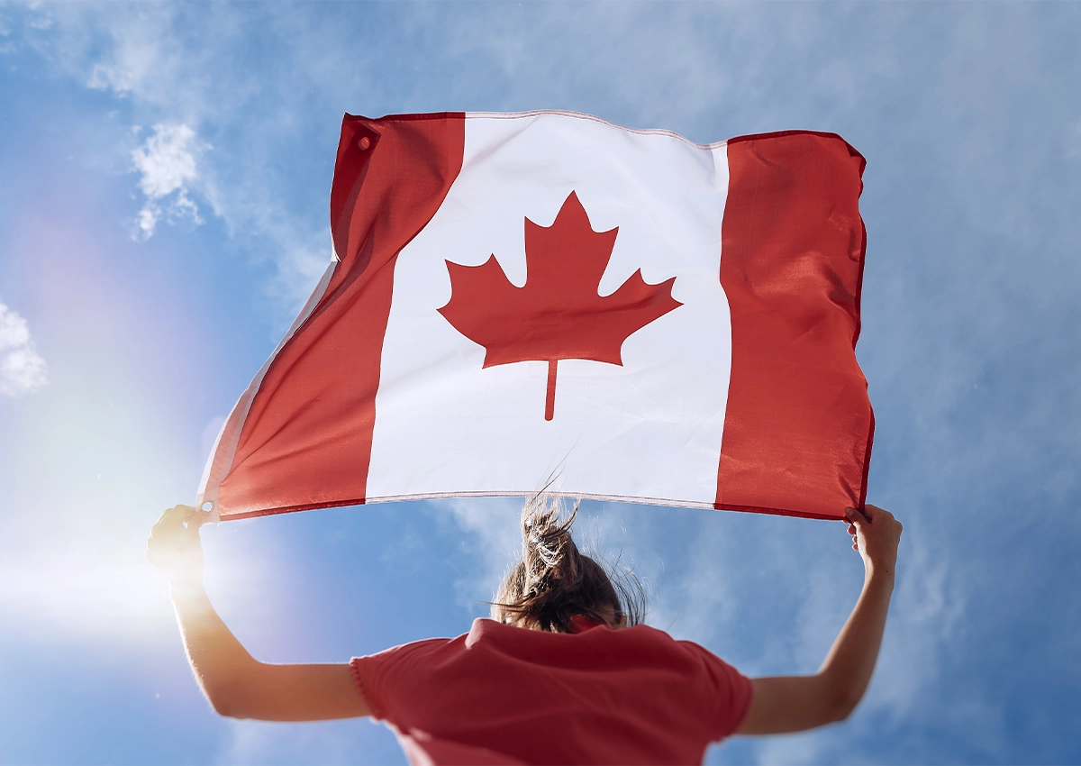 Une personne tenant le drapeau canadien.