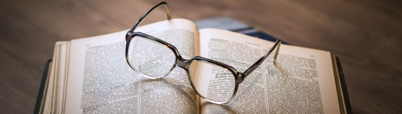 Glasses laid on open book