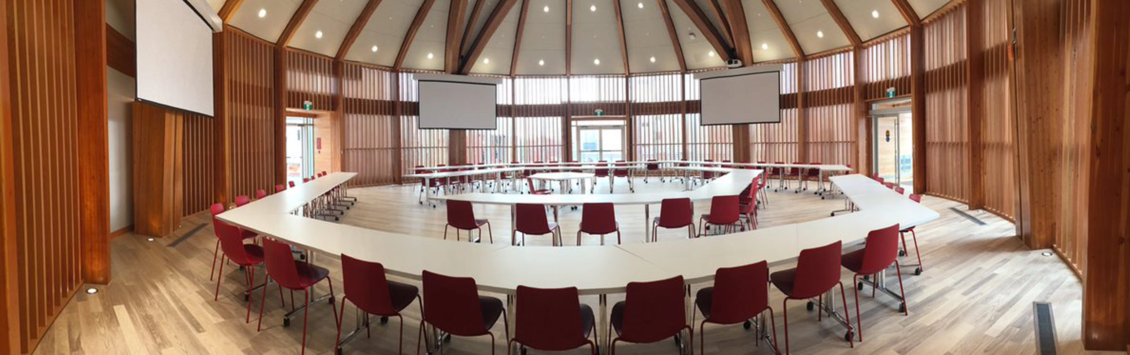 Le Centre Autochtone de partage et d'apprentissage avec des tables disposées au milieu de la salle ronde.