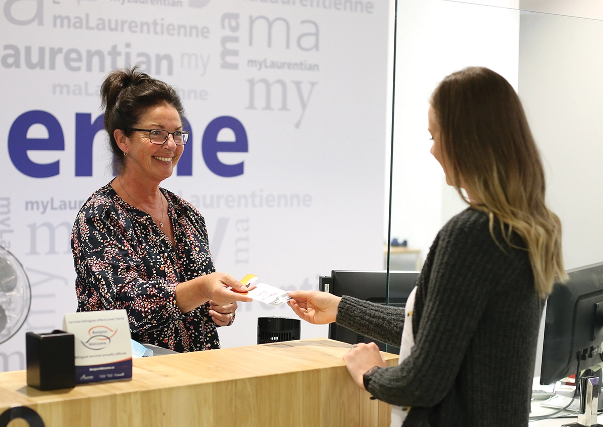 A Laurentian University student being helped by a staff member at the Hub service desk.