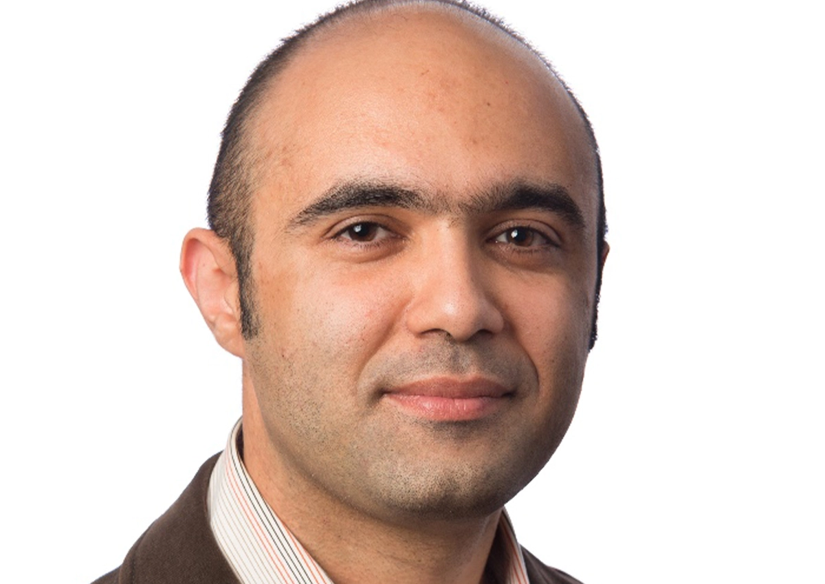 Kamran Eshghi's headshot. he is smiling at the camera with a white background