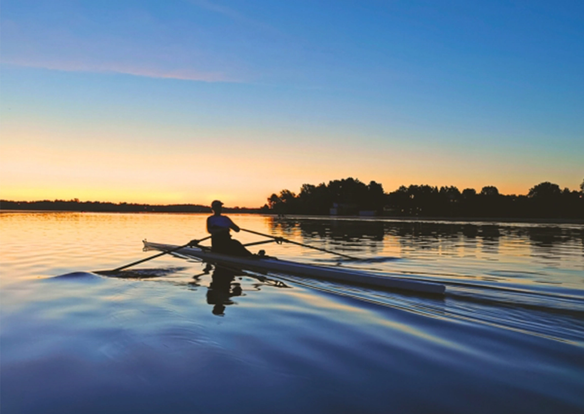 Un étudiant de l'Université Laurentienne faisant du kayak sur un lac au coucher du soleil.