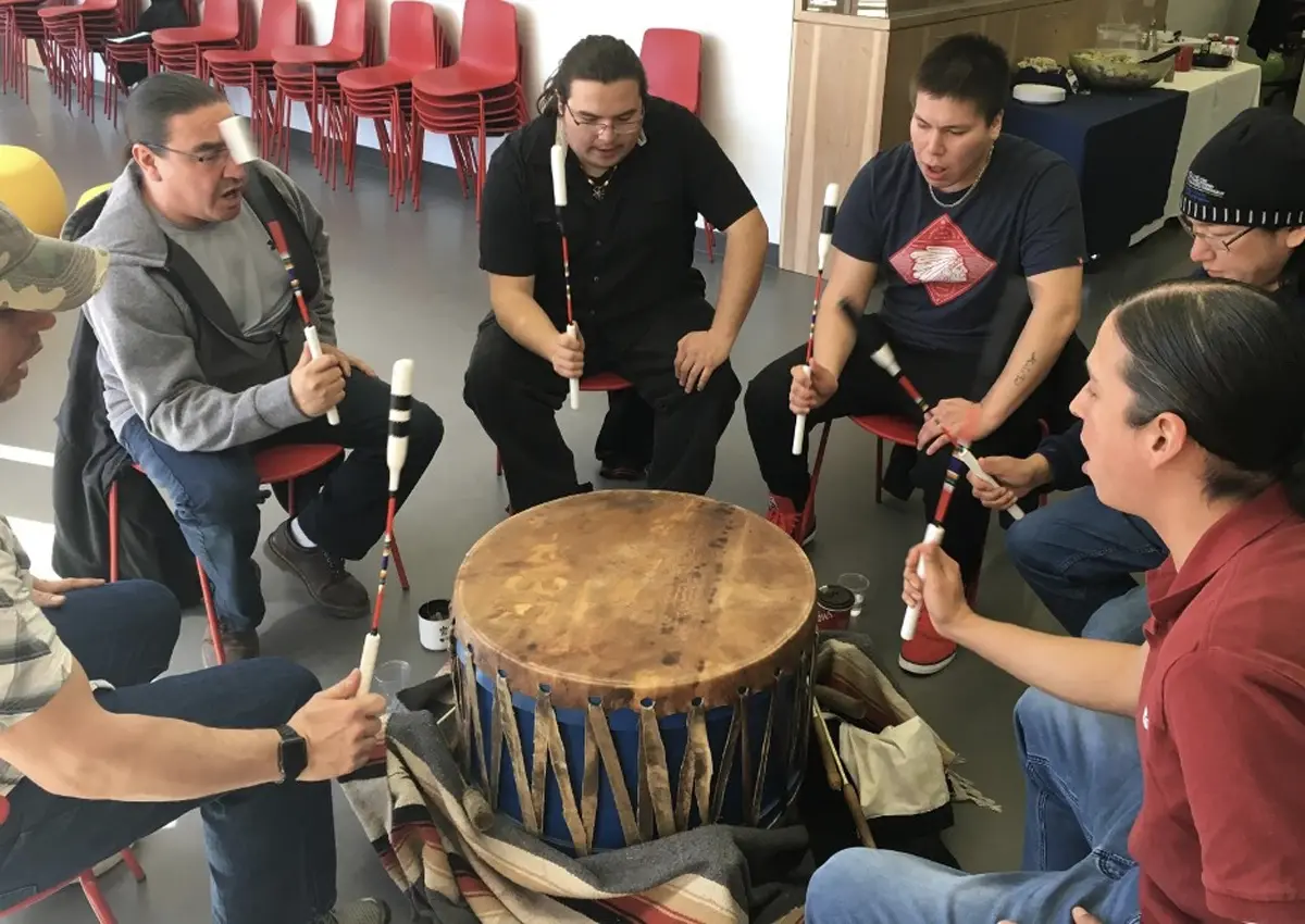 A group of people using a ceremonial drum.