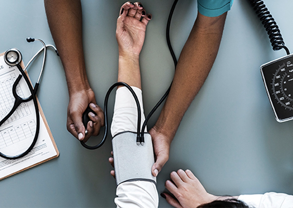 A healthcare provider checks their patient's blood pressure.