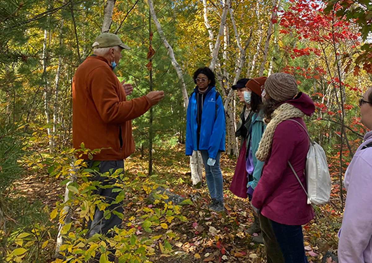 Un groupe d'étudiants sur un sentier, écoutant un professeur.
