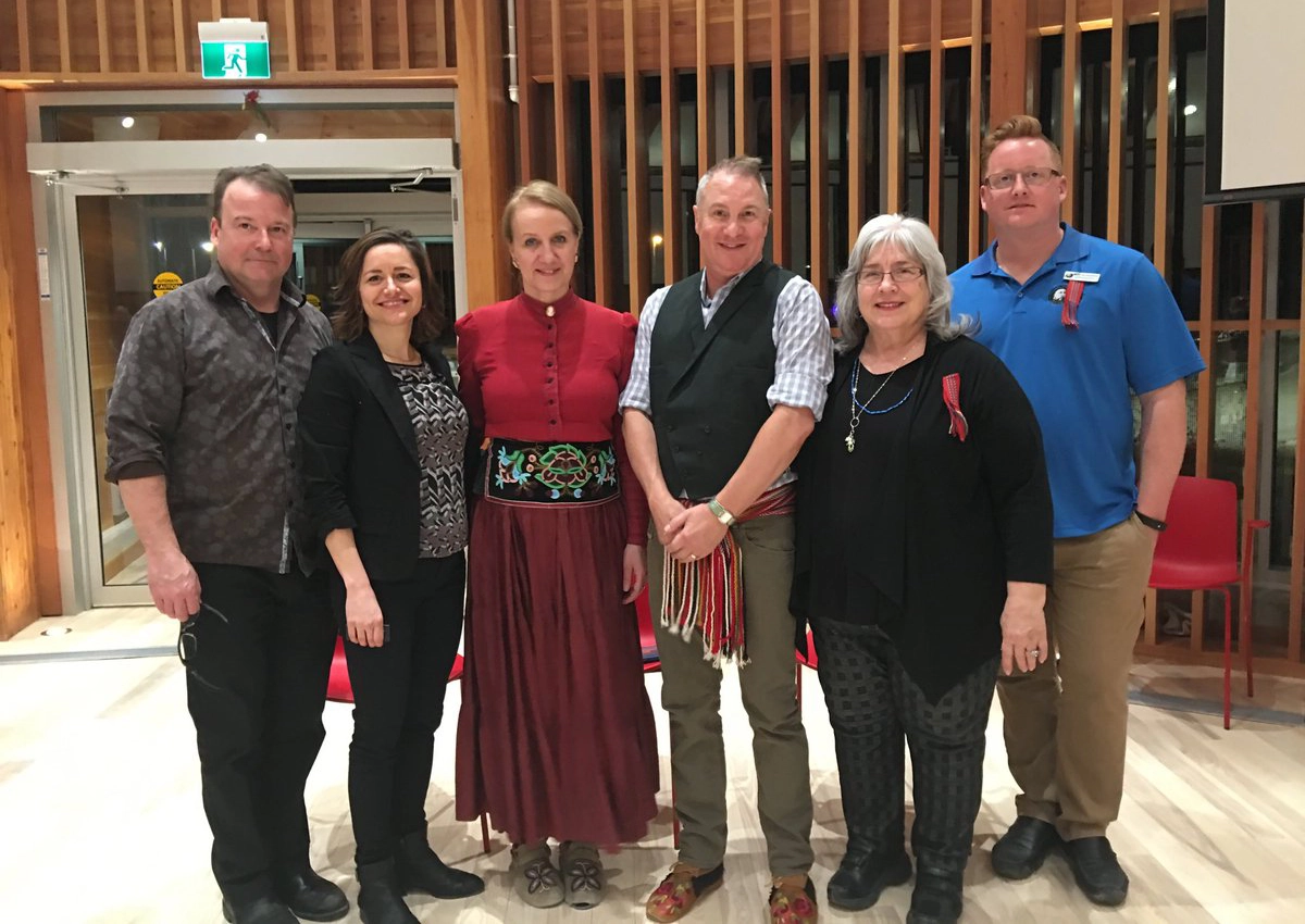 A group of 6 people in the ISLC Round Room, dressed in traditional Indigenous clothing for Métis Cultural Day.