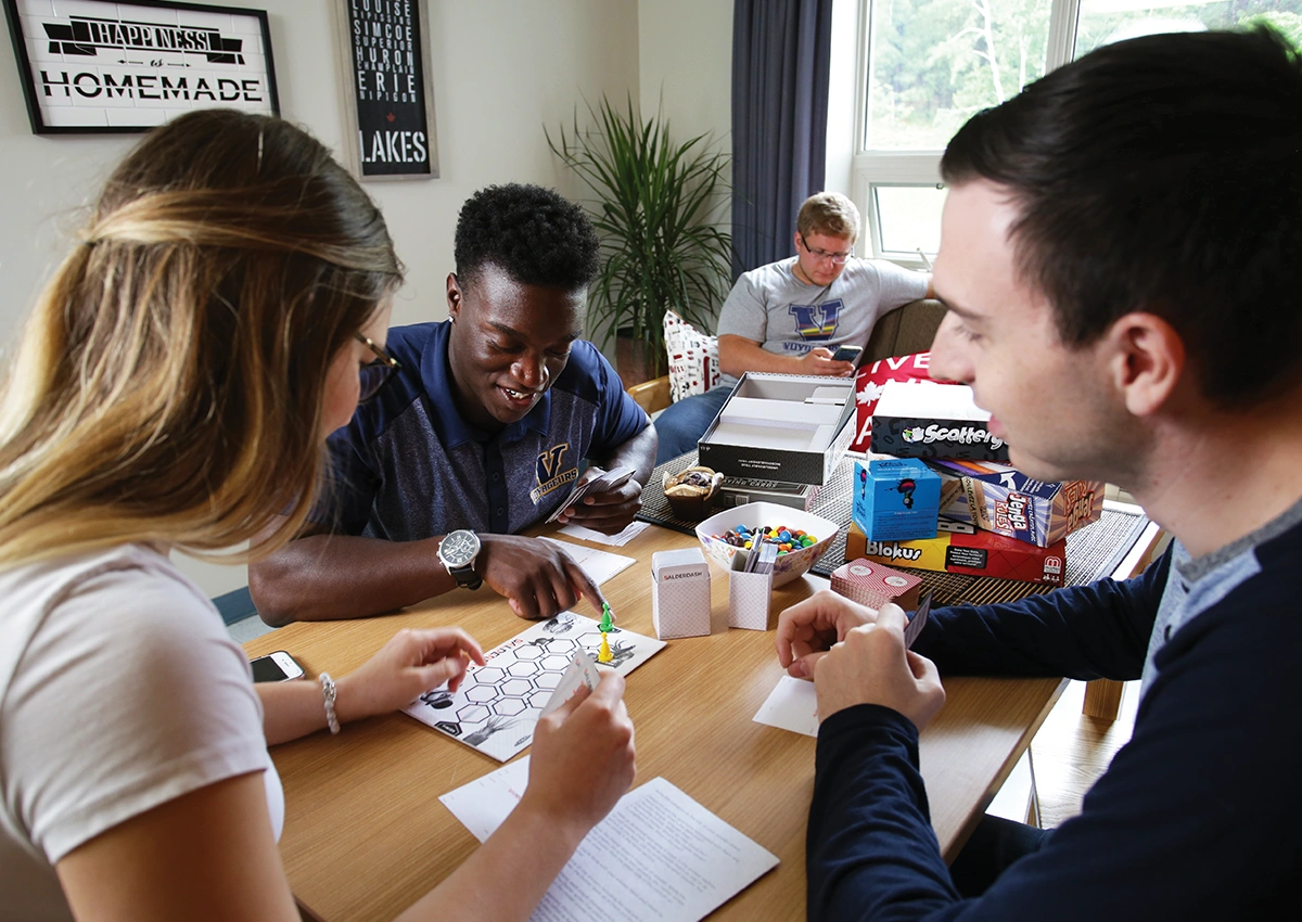 Laurentian University students playing a game int heir residence room.