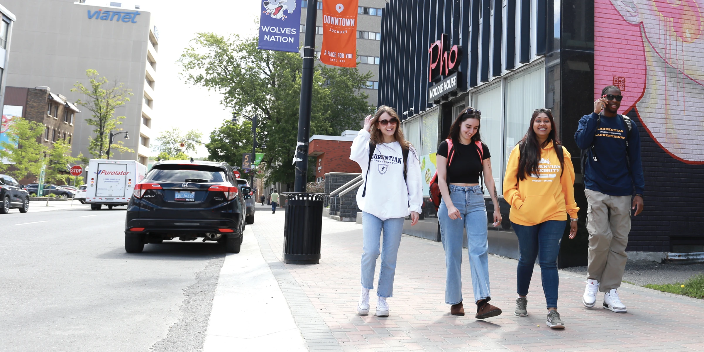 A group of four Laurentian students walking in downtown Sudbury.