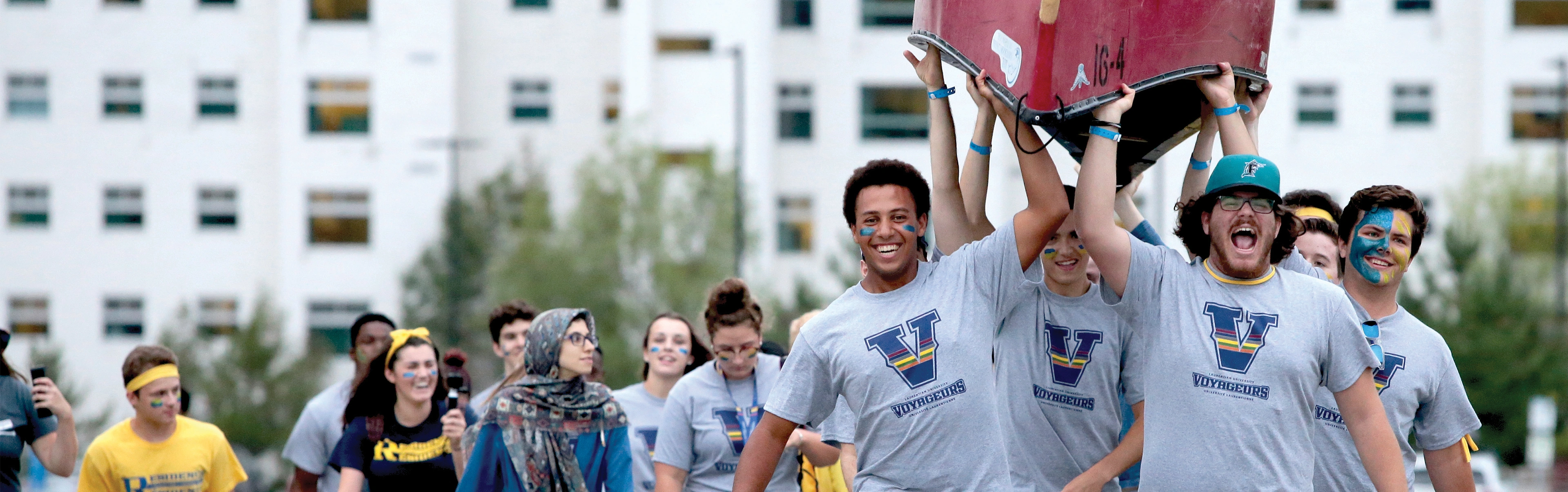 Laurentian University students carrying a canoe during Orientation.
