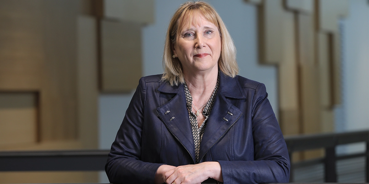 Laurentian President Lynn Wells standing by a railing looking towards the camera.