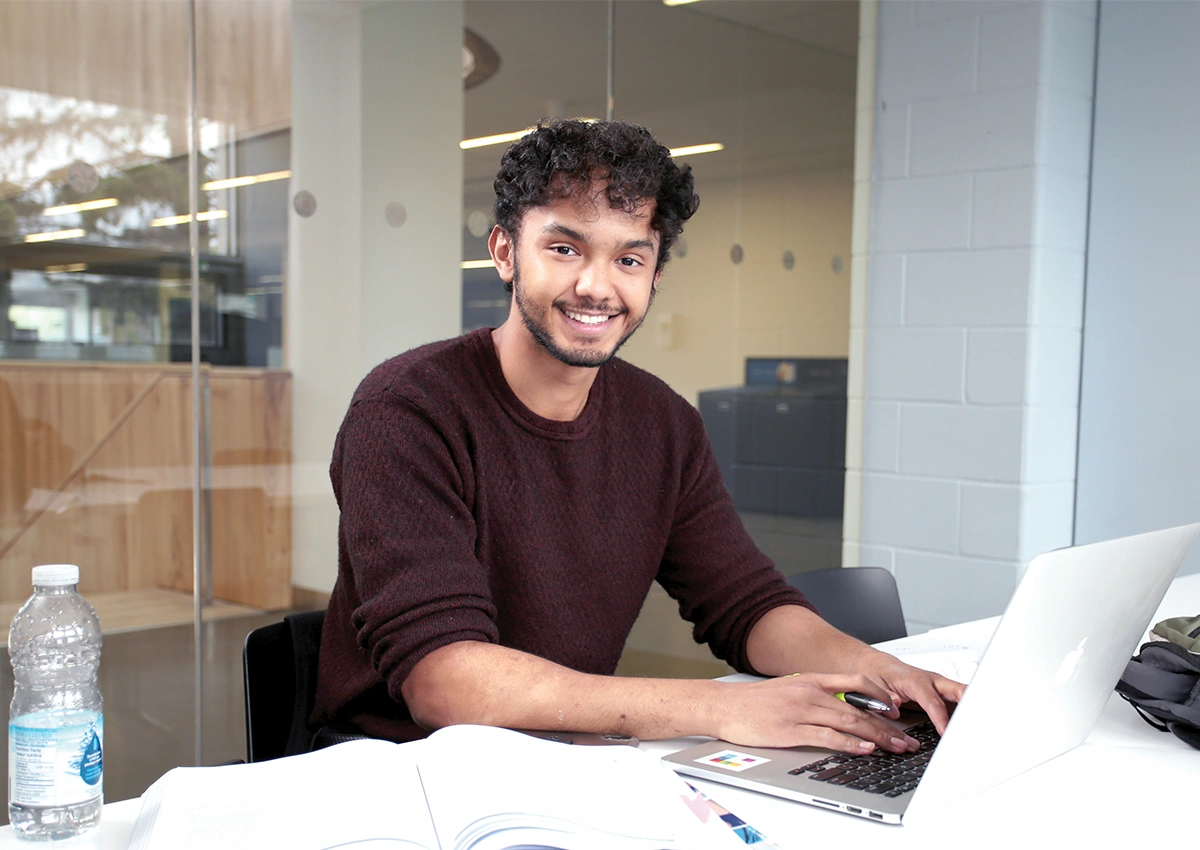 A Laurentian University student on his laptop in a study room in R.D. Parker building.