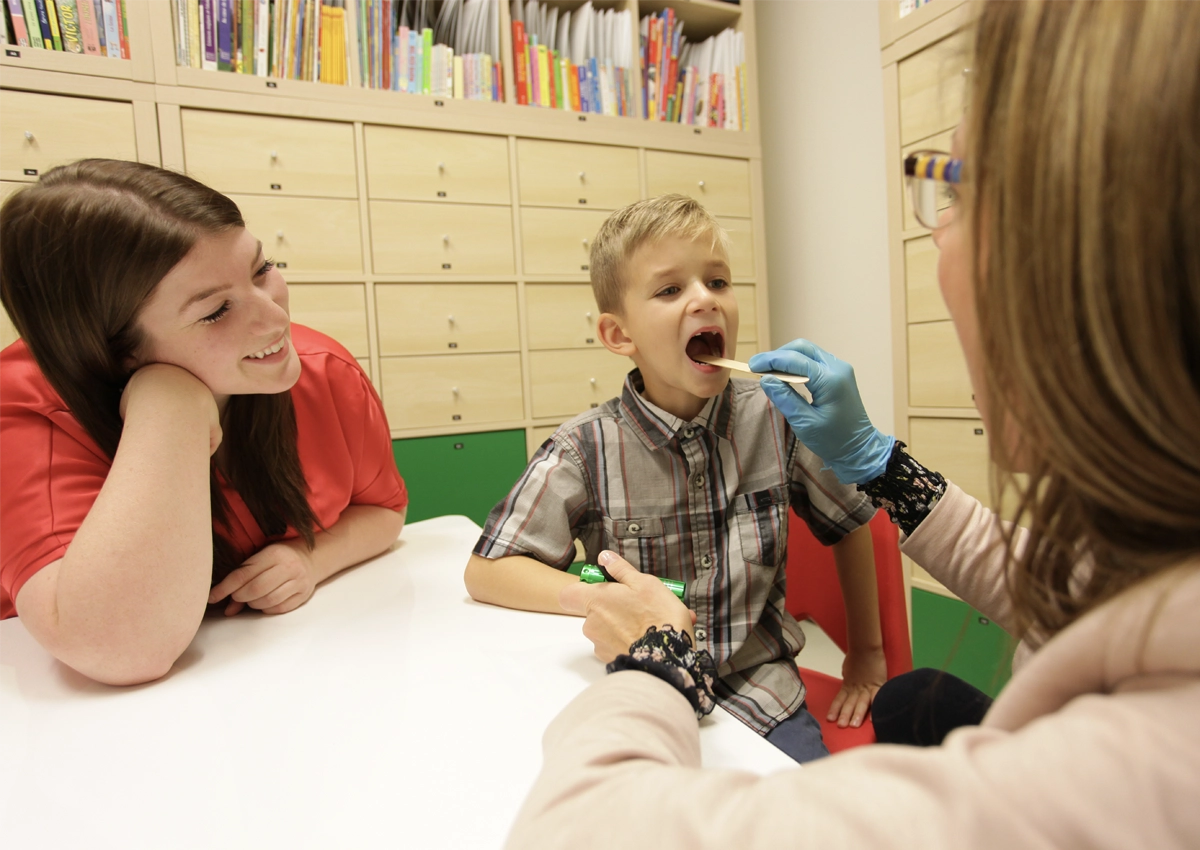 Une orthophoniste de la clinique d'orthophonie de l'Université Laurentienne examine un jeune patient.