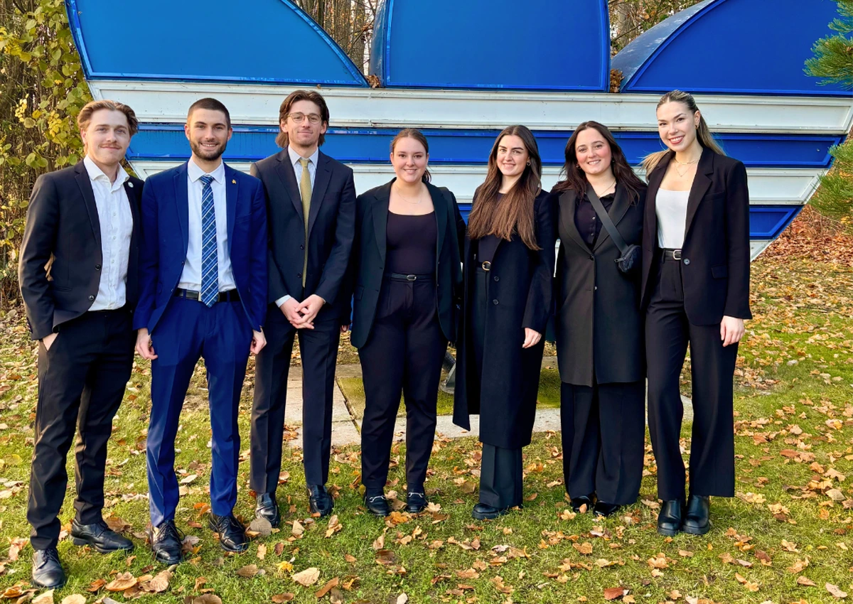 Sports Administration students pose in front of the adidas sign at their headquarters in Germany.