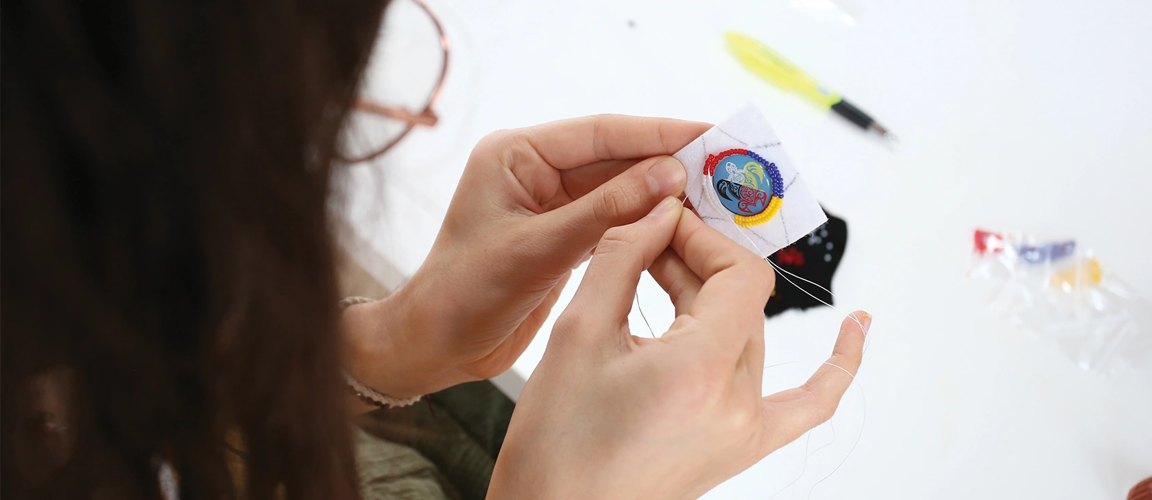 A Laurentian University student beading Indigenous earrings.
