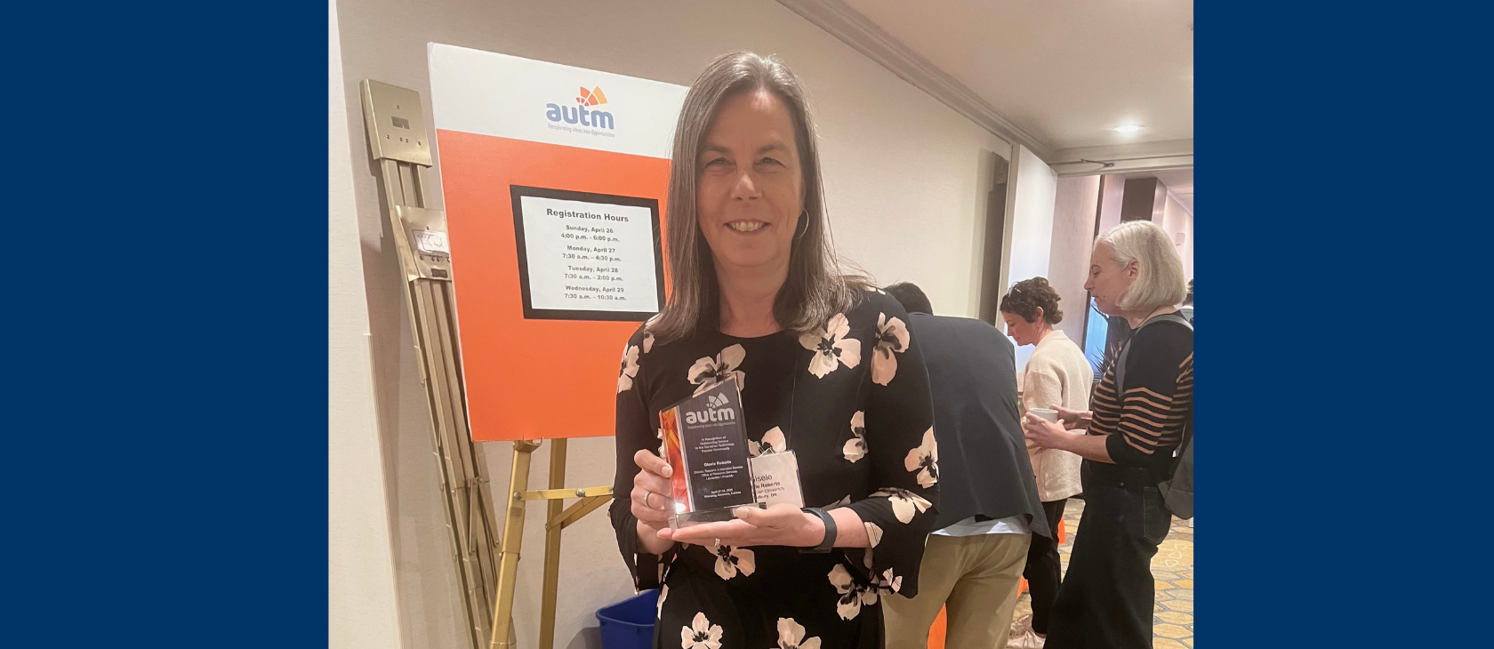 Gisele Roberts, Director of Research and Innovation, smiles while holding her AUTM Canadian Award for excellence in technology transfer.