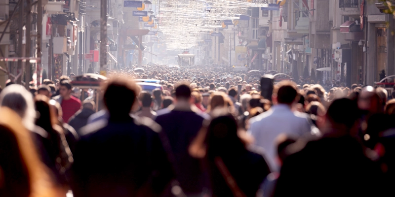 A crowd of people walking in a city.