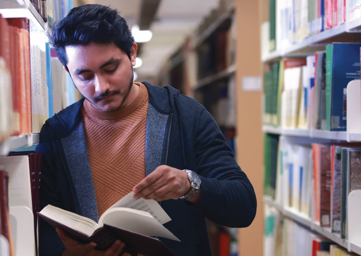 A Laurentian University student reading a book in the J.N. Desmarais Library.