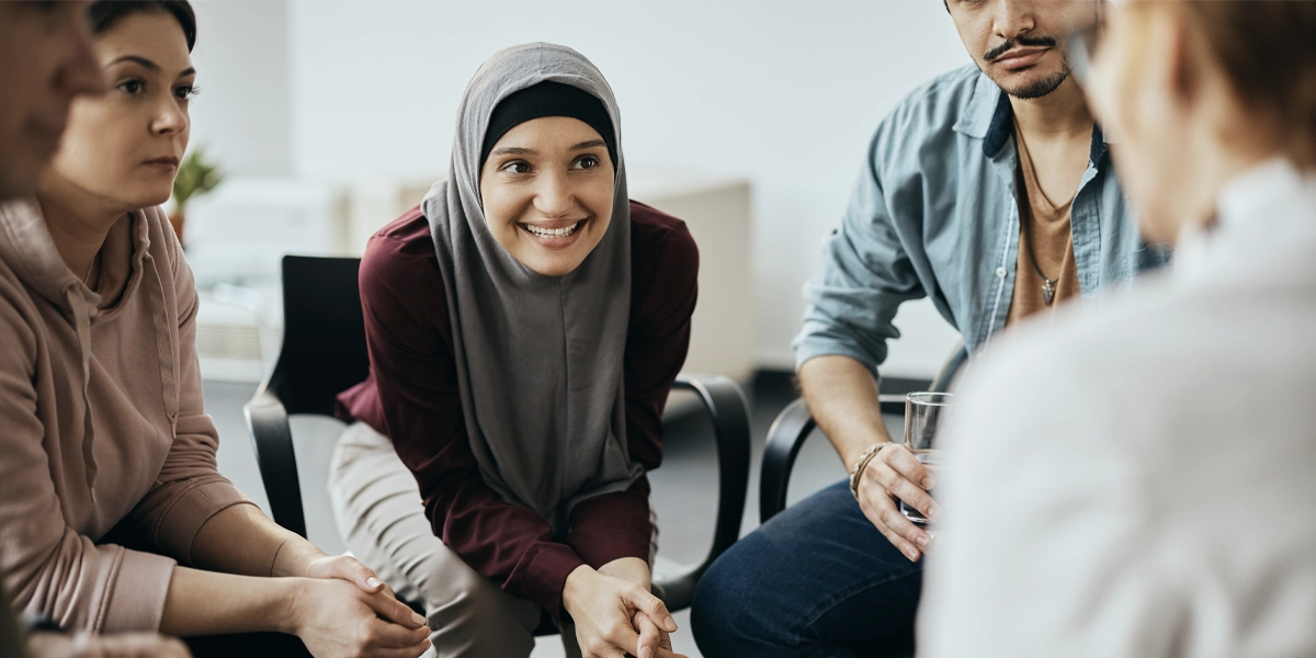 A group of people smiling, in conversation.
