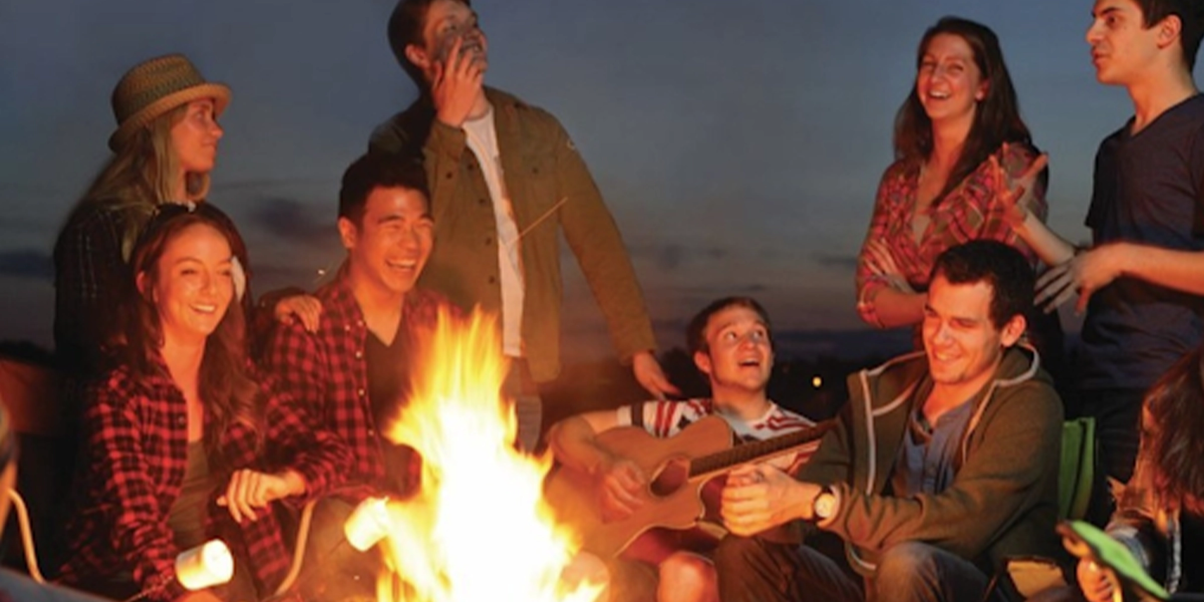 People gathered around a bonfire signing