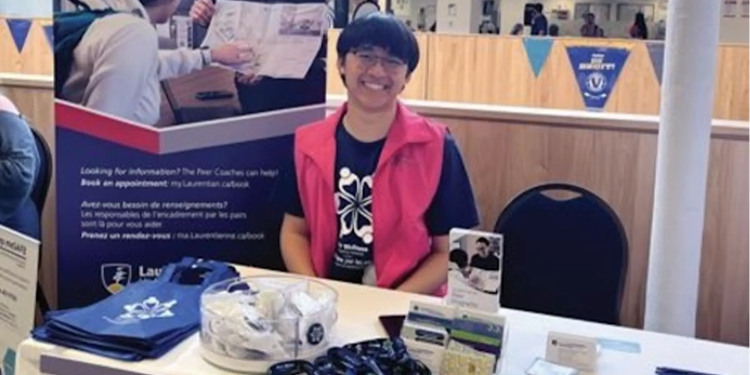 Student sitting at event table smiling
