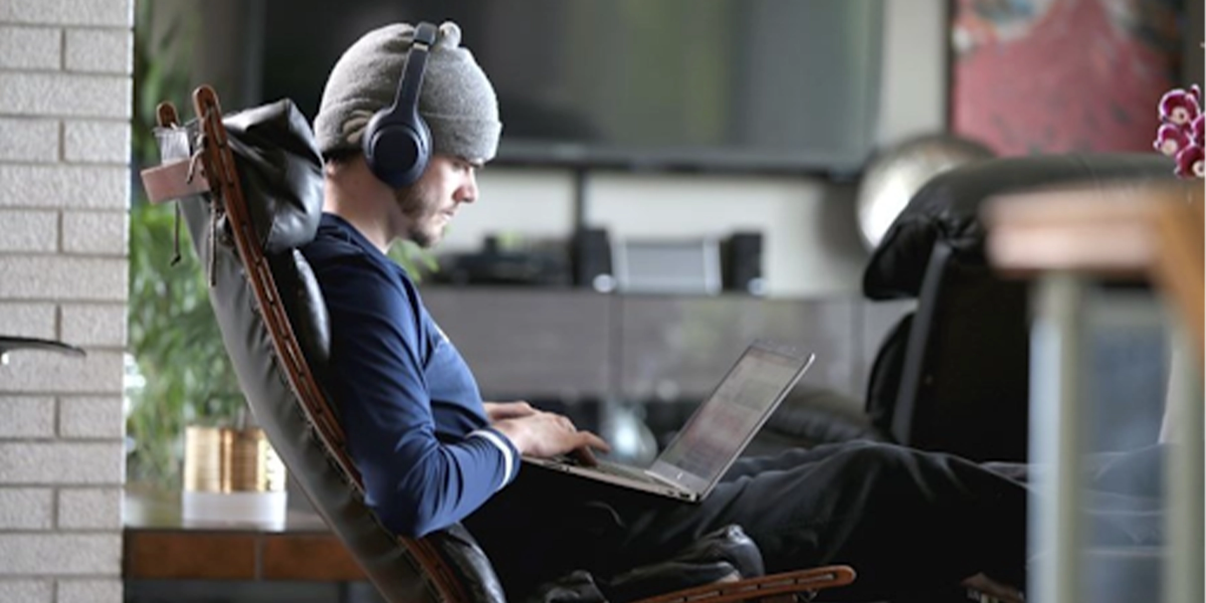 Person with headphones doing work on his laptop