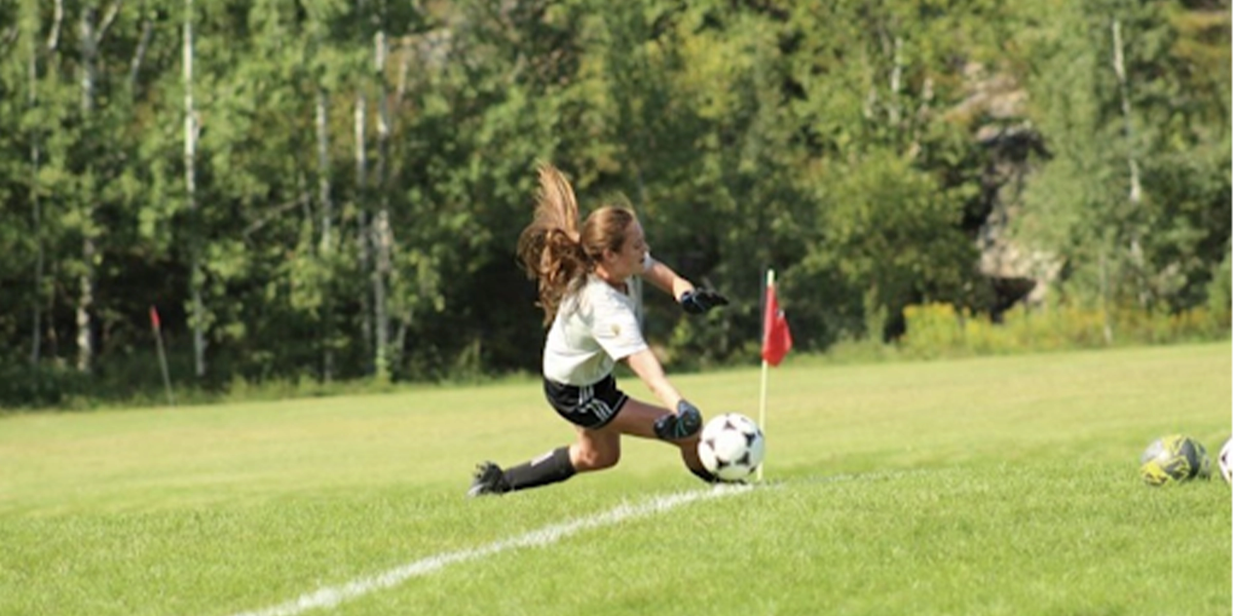 Female soccer player diving for ball