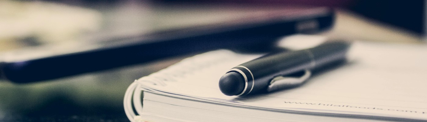 A pen sitting on top of a pile of papers