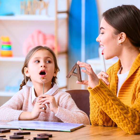 Une orthophoniste qui travaille avec un enfant.