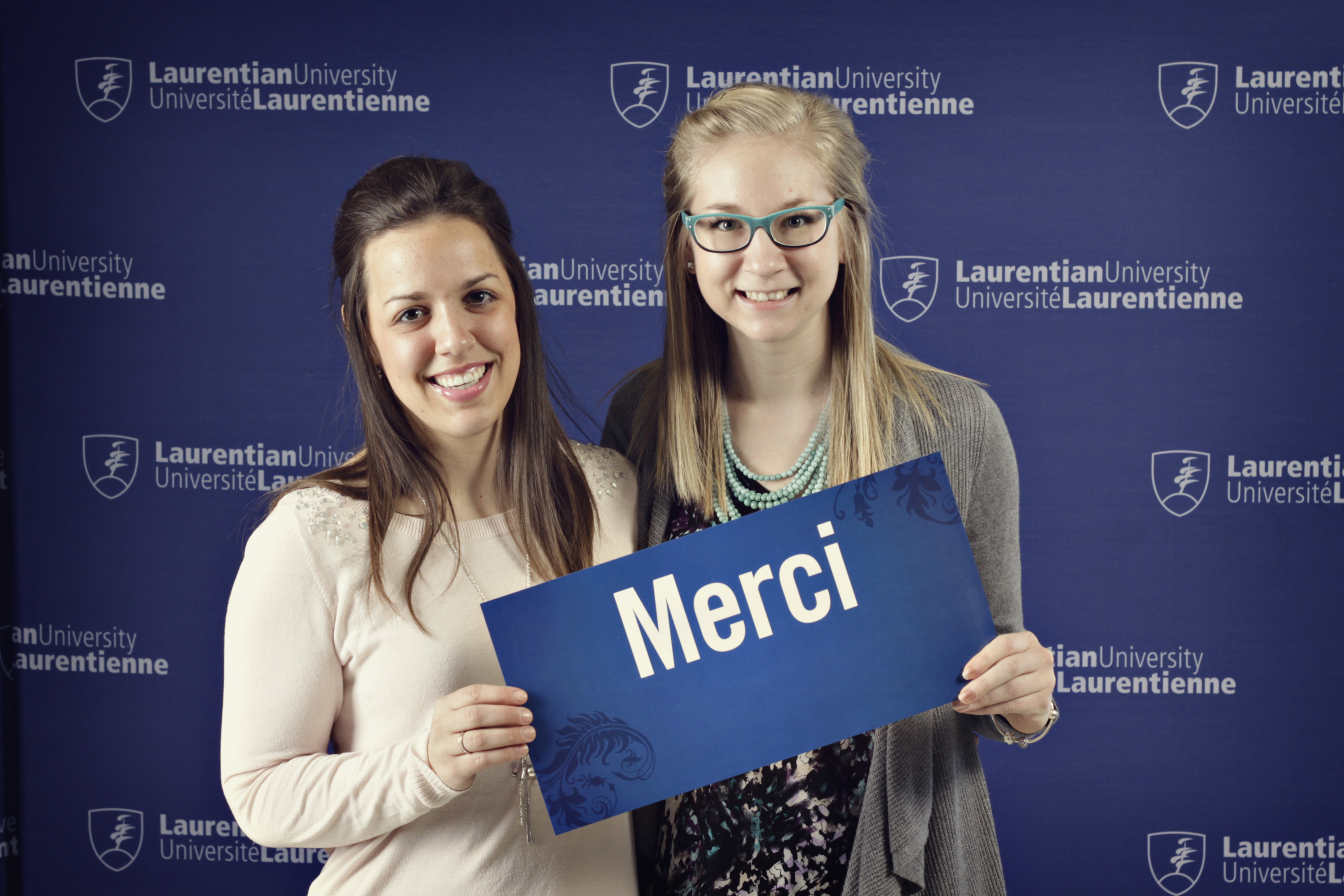 Des étudiants tiennent une affiche de remerciement