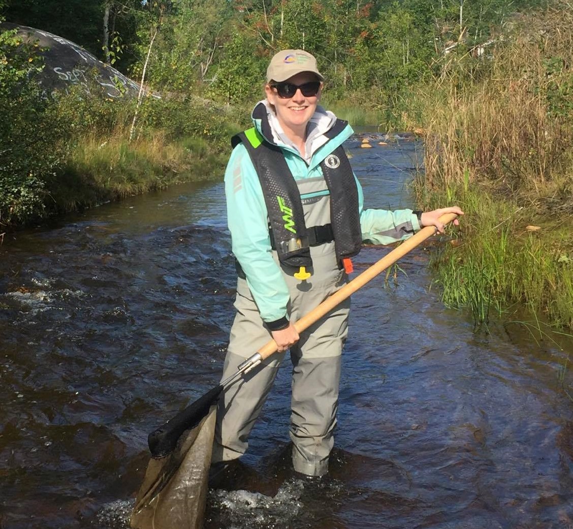 Brie Edwards standing in a river holding a net