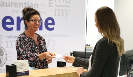 A Laurentian University student being helped by a staff member at the Hub service desk.