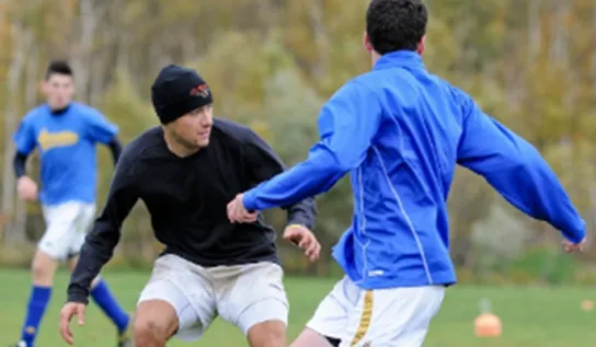 Des hommes jouant au football sur un terrain.