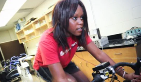 Une femme faisant du vélo d'appartement dans un laboratoire de recherche.
