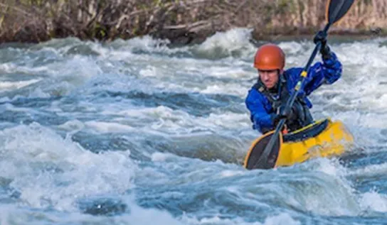 Deux hommes faisant du kayak sur une rivière.