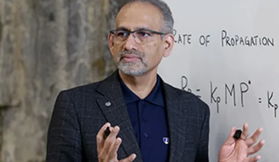 a professor teaches equations at a white board