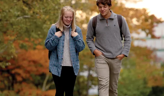 Deux étudiants de l'Université Laurentienne marchant sur le campus à l'automne.