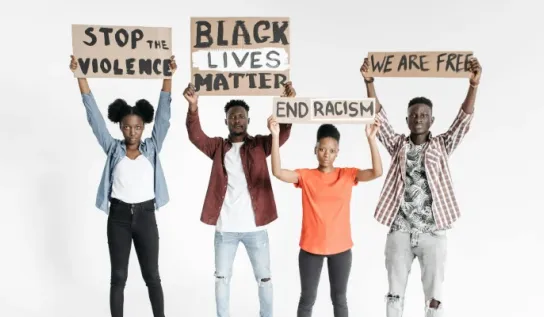 Several people holding up signs to help end racism