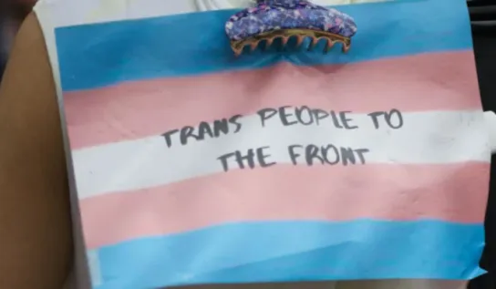 Transgender flag with Trans people to the front written on it