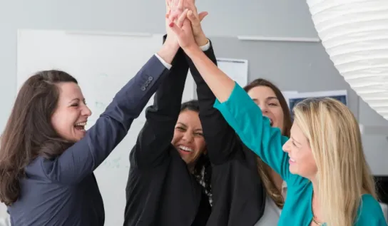 Several women having a group high-five