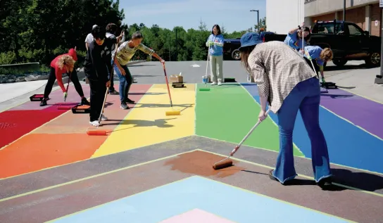 Laurentian University painting the Pride crosswalk on campus.