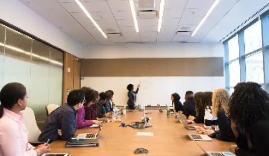 A presenter in front of a board room 